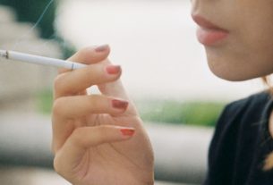 Une jeune fille fumant une cigarette.