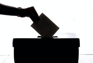 Une personne mettant son vote dans l'isoloir.