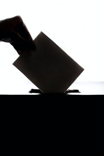 Une personne mettant son vote dans l'isoloir.